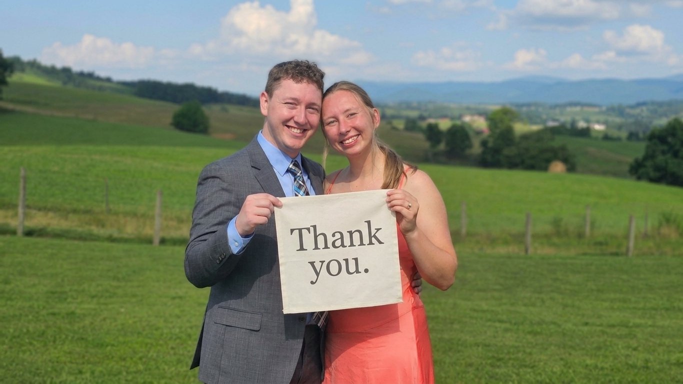 Dylan and Madeline holding a hand-lettered thank you banner
